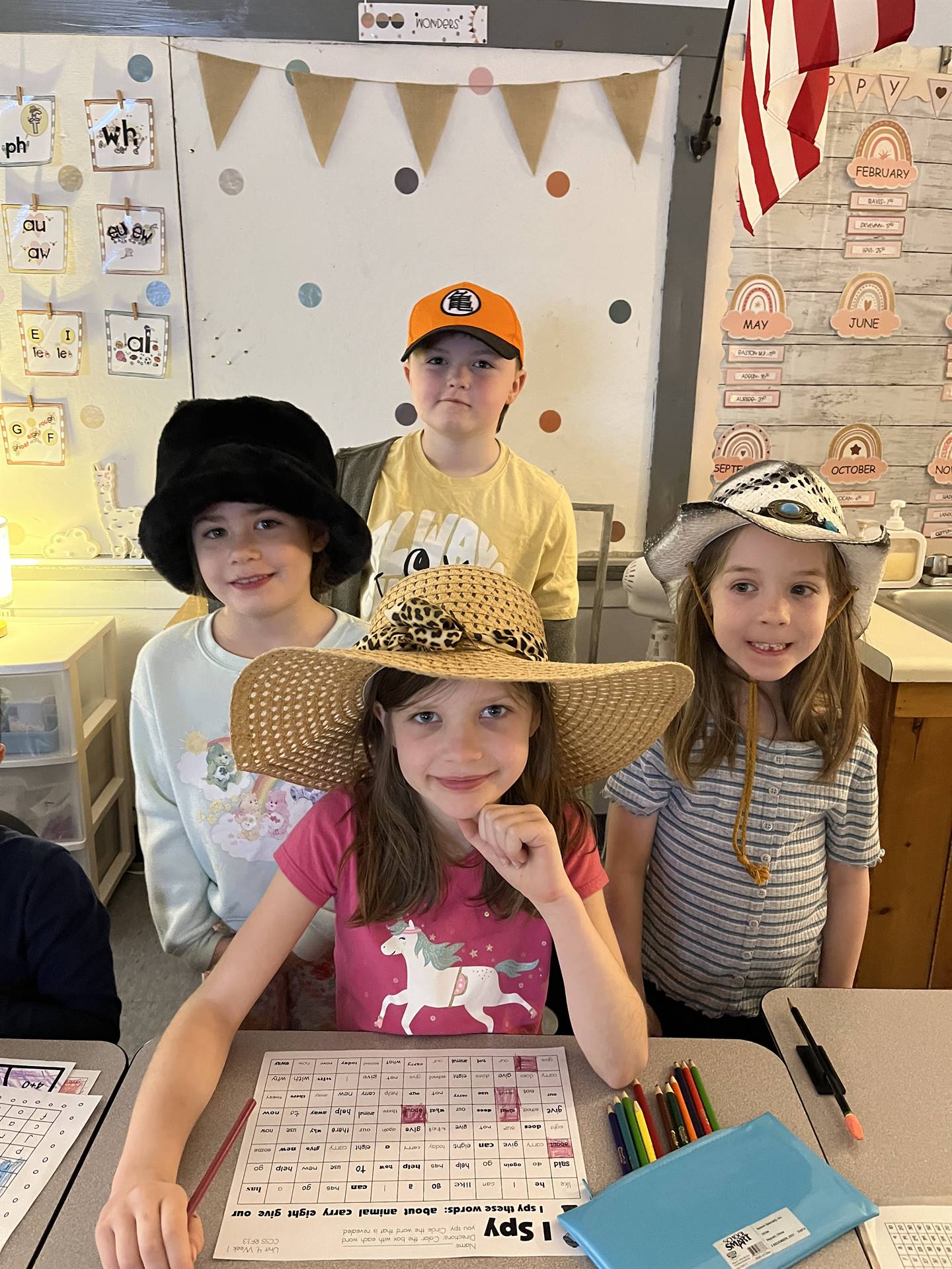 1 student with a fuzzy black hat, 1 student with a baseball cap, 2 student with flower garden hats