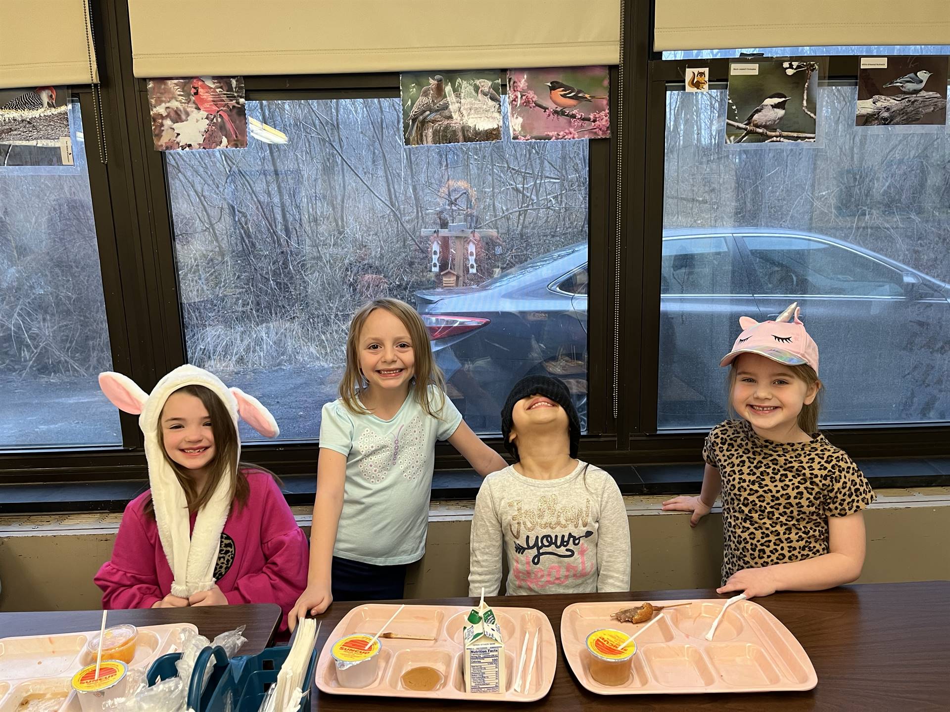 4 students with different hats on their head