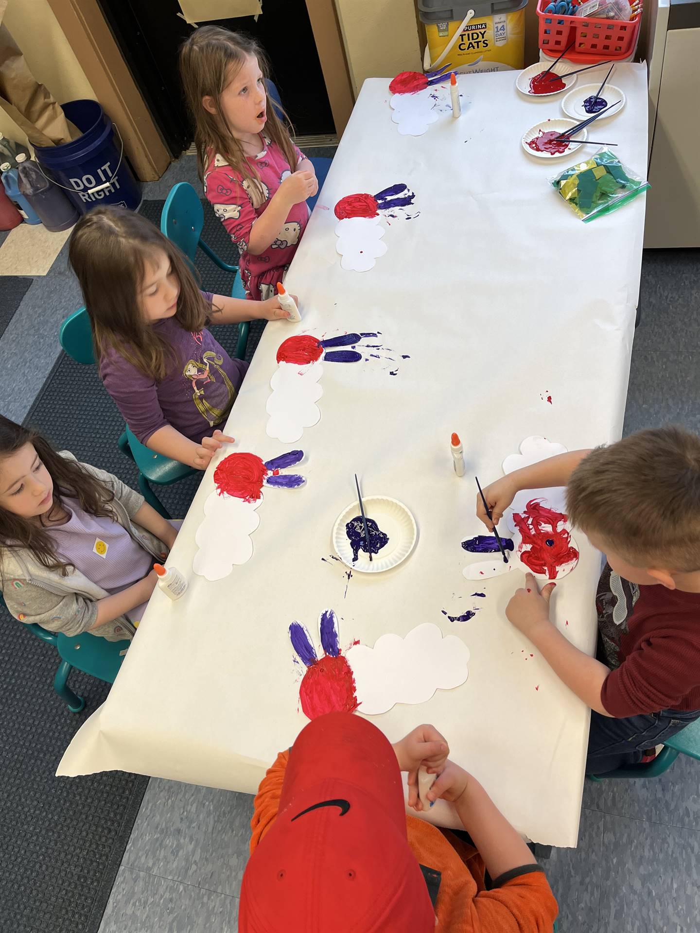 4 students painting a red circle and blue antenna!