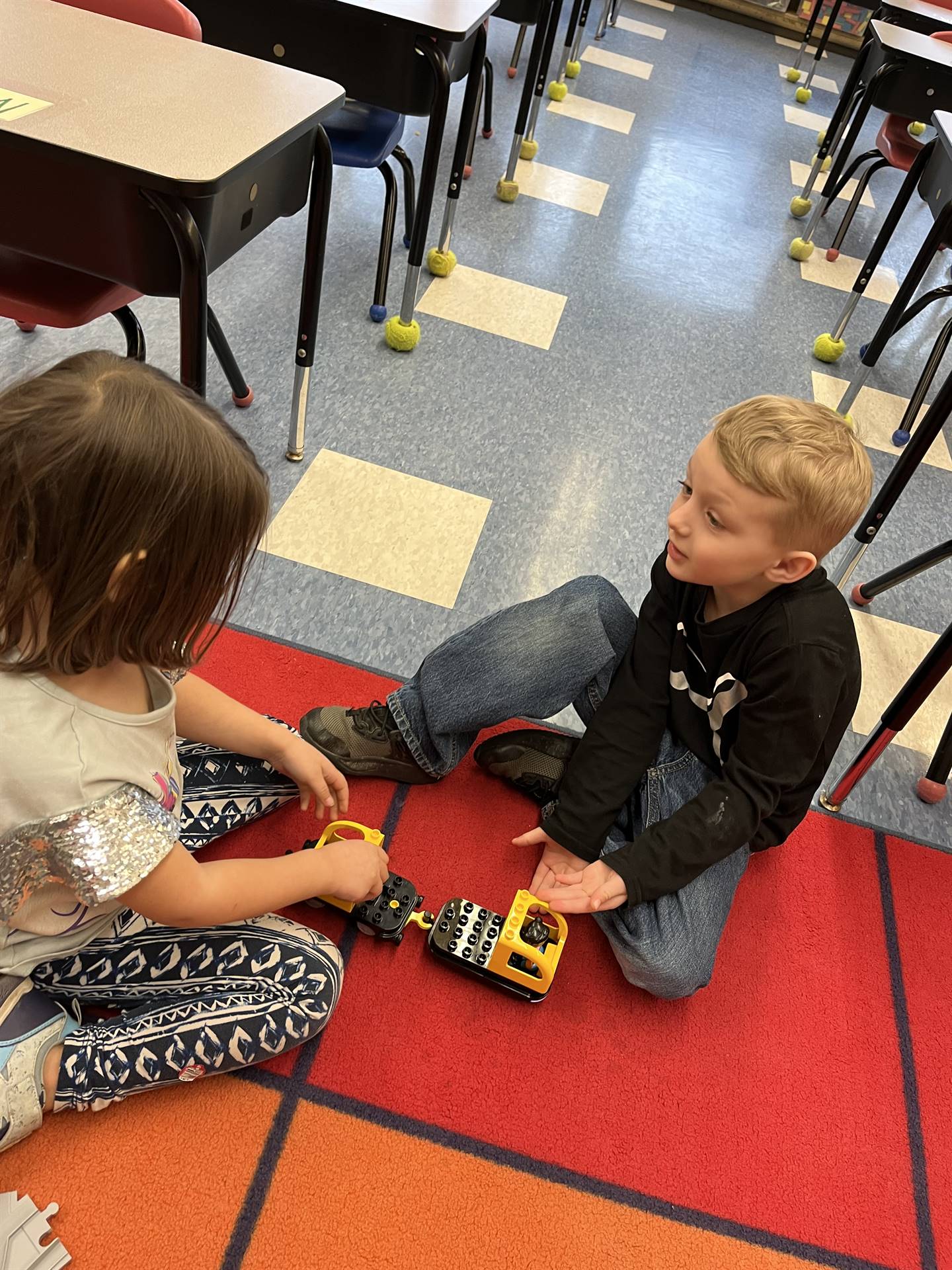 2 students work together on a train track.