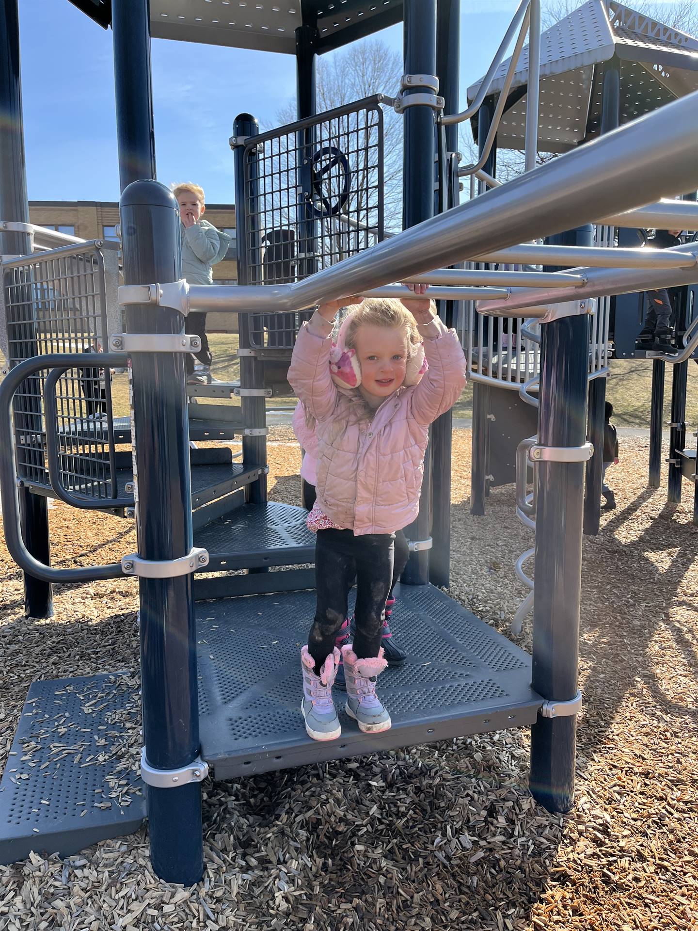 a student begins on monkey bars outdoors.