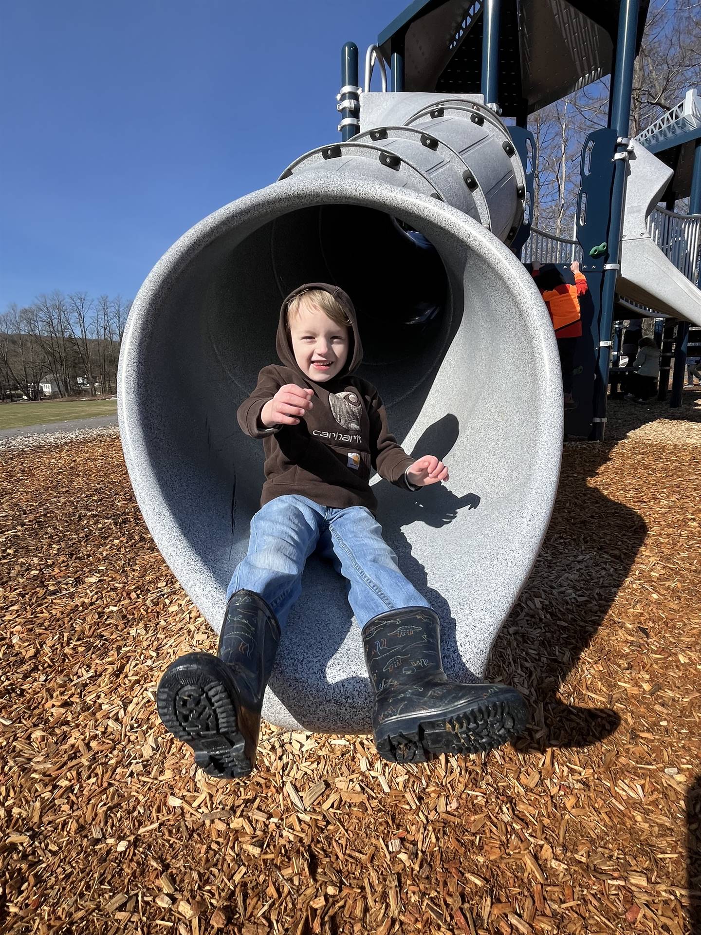 a student at the end of a round slide tunnel