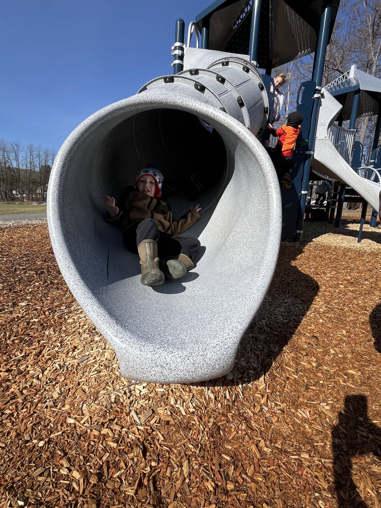 a student at the end of a round slide tunnel