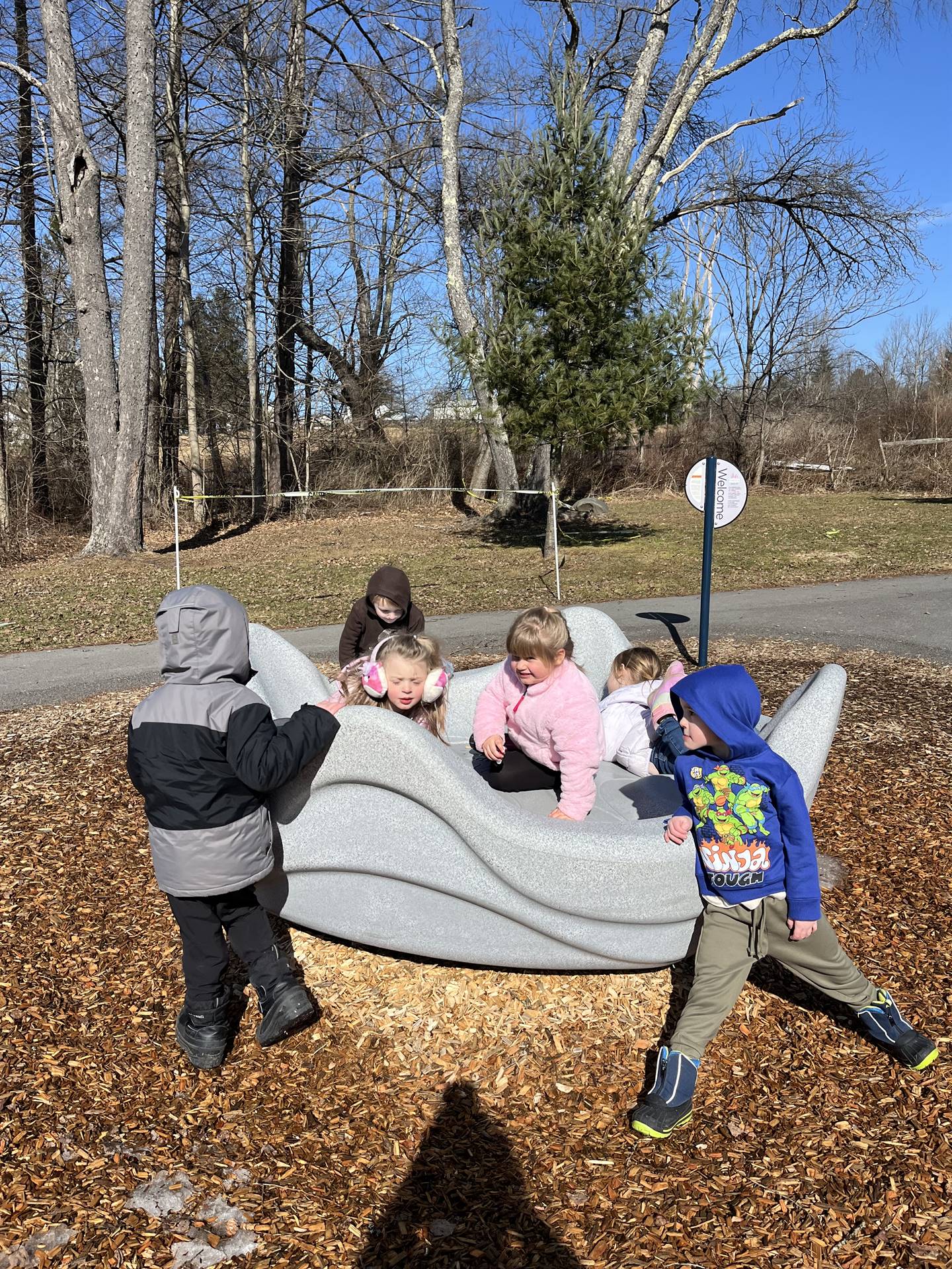a group of students on a giant clam merry go round outdoors.