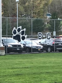 All weather fence cups on the soccer field fence spell B-G!